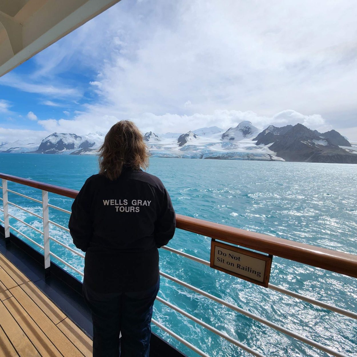 Wells Gray Tour Director standing on deck of cruise ship looking at the stunning view in Antarctica